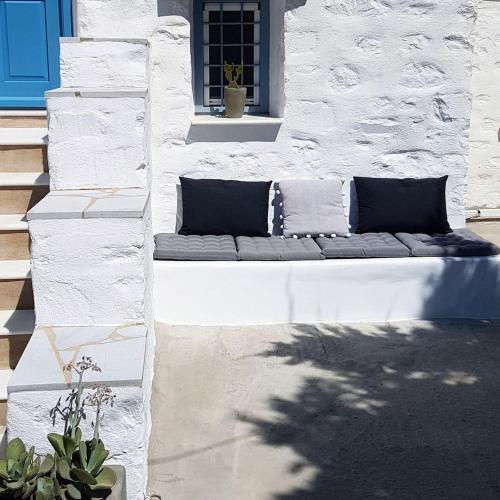 a couch sitting on the side of a building at Island Magic - Seaview Villa with Jacuzzi Pool in Ambelas