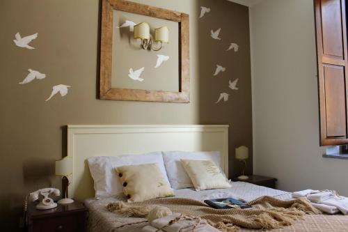 a bedroom with a bed with white birds on the wall at Albergo Merùo in Morano Calabro