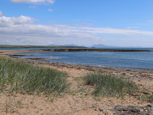 a beach with some grass and some water at Old Tollgate in Holyhead