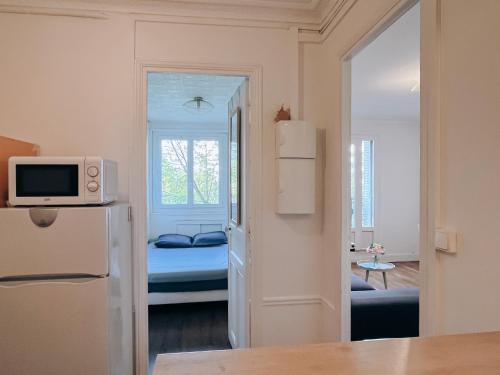 Cette petite chambre comprend un lit et un réfrigérateur. dans l'établissement Appartement A deux pas de Gare de Lyon, à Paris