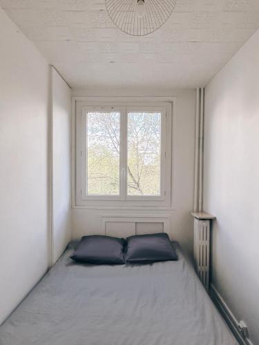 un lit dans une petite pièce avec une fenêtre dans l'établissement Appartement A deux pas de Gare de Lyon, à Paris