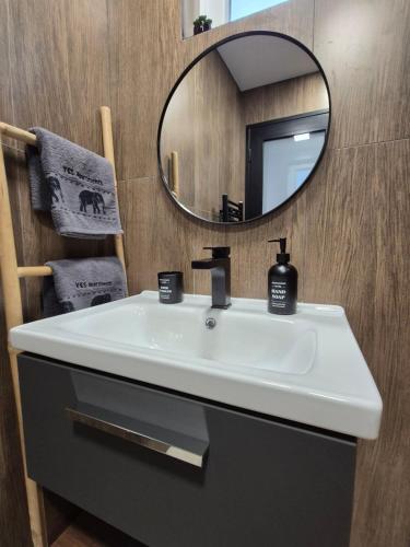 a bathroom with a white sink and a mirror at V&S apartments 1 in Sliven