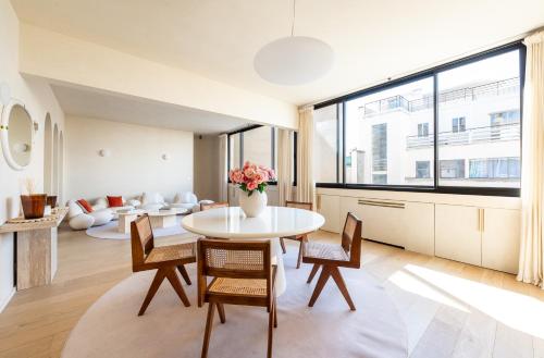 un salon avec une table et des chaises dans l'établissement Lease Mobility l Champs-Elysée & Eiffel View l Triplex 2BR & Rooftop, à Paris