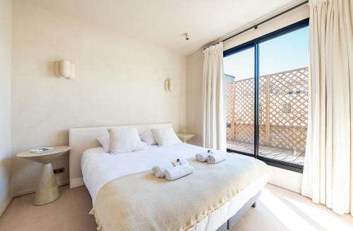 une chambre avec un lit et une grande fenêtre dans l'établissement Lease Mobility l Champs-Elysée & Eiffel View l Triplex 2BR & Rooftop, à Paris