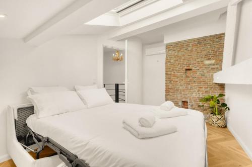 une chambre avec un lit blanc avec deux serviettes dessus dans l'établissement Nero Marquina - Climatisé proche métro, à Toulouse