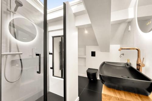 La salle de bains est pourvue d'une baignoire noire et d'une douche. dans l'établissement Nero Marquina - Climatisé proche métro, à Toulouse