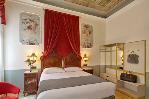 a bedroom with a bed with a red curtain at UNAHOTELS Ala Venezia-Adults 16 in Venice