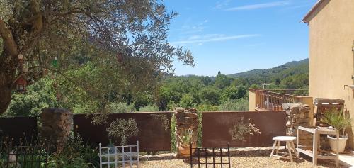 une cour avec une clôture, une table et des chaises dans l'établissement BIENVENUE, à Le Revest-le-Eaux