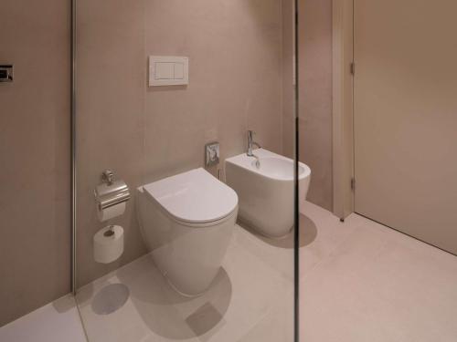 a bathroom with a white toilet and a sink at Mercure Ponta Delgada Azores in Ponta Delgada