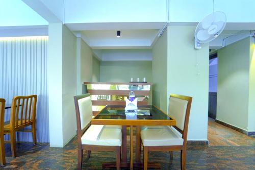 a dining room with a wooden table and chairs at Treebo Park Palace in Guwahati