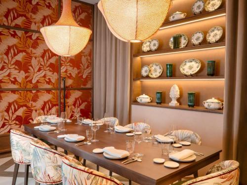 a dining room with a table with chairs and plates at Fairmont La Hacienda Costa del Sol in Alcaidesa