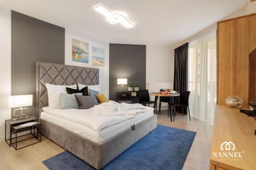 una camera da letto con un letto grande e una sala da pranzo di Apartament Premium Lux - tuż przy morzu-baseny,sauny i jacuzzi w CENIE! -Pinea Apartments Pobierowo-SANNEL Apartments for rent a Pobierowo