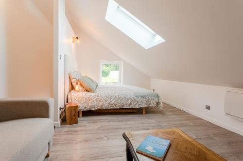 a bedroom with a bed and a skylight at Gîte Avec Jacuzzi Chic & Cosy entre Caen et la Mer en Normandie in Biéville-Beuville