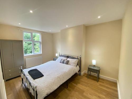 a bedroom with a bed and a window at Stunning South Croydon Apartment - Relax in Style in Purley