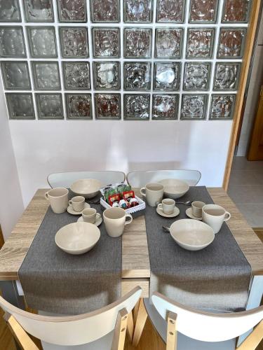 a table with bowls and cups and a bowl of fruit at Balcón del atardecer in Cangas de Onís