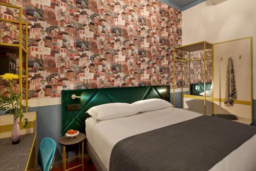 a bedroom with a bed and a wall covered in tiles at UNAHOTELS Ala Venezia-Adults 16 in Venice