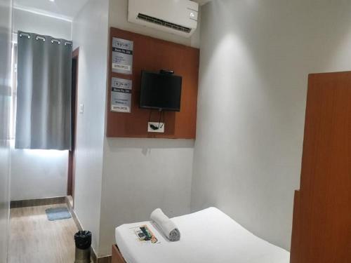 a room with a bed and a tv on the wall at Hotel Hi City Inn Near ISBT in Guwahati
