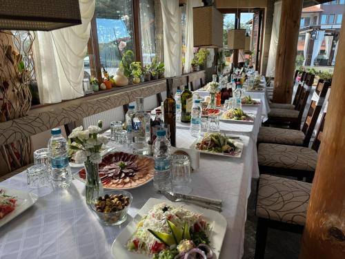 a long table with plates of food on it at Family Hotel Eterno in Tsigov Chark