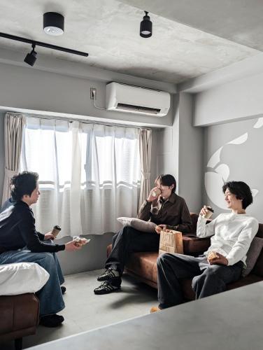 a group of people sitting on a couch in a room at ART HOTELS SHIBUYA in Tokyo