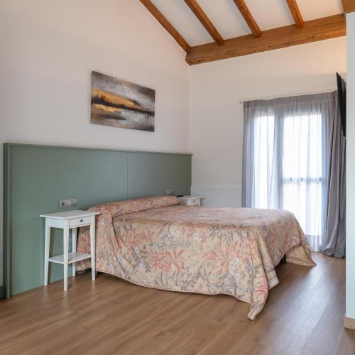 a bedroom with a large bed and a table at Casa de Amancio in Lavacolla