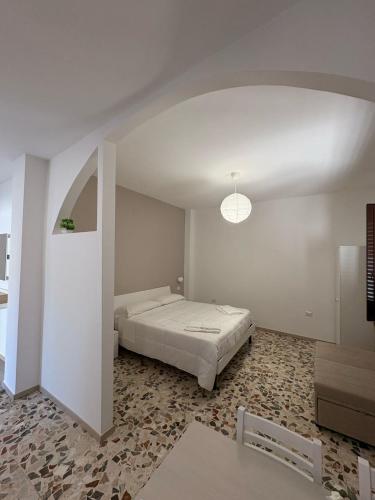 a white room with a bed and a table at Da Peppino e Nicchella in Marina di Camerota