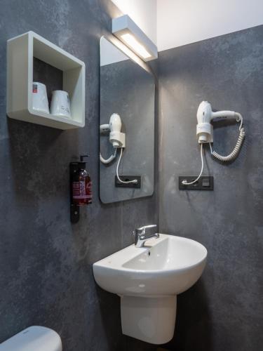 a bathroom with a sink and a toilet and a mirror at Casa de Amancio in Lavacolla