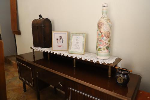 a wooden table with a bottle and pictures on it at Bujtina Ethan Perondi in Kuçovë