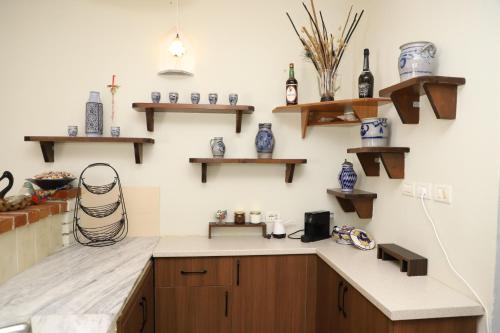 a kitchen with wooden cabinets and shelves on the wall at Bujtina Ethan Perondi in Kuçovë