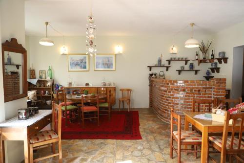 a dining room with tables and chairs and a brick wall at Bujtina Ethan Perondi in Kuçovë