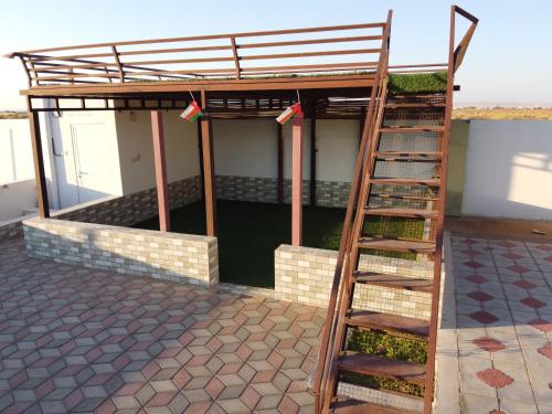 a bunk bed on top of a building with a ladder at Luban Camping House in Bidiyah