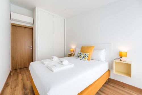 a bedroom with a white bed with two towels on it at GuestReady – The Mythic Apartments in Porto