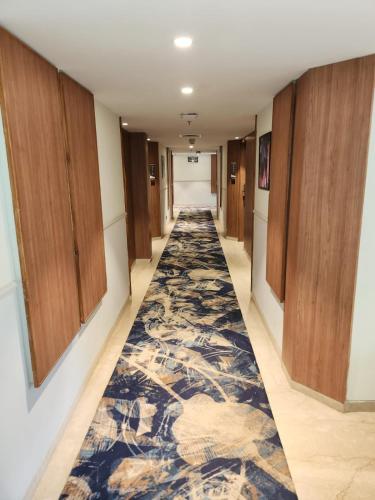a hallway with a carpeted floor and wooden cabinets at The Central Park Hotel in Gwalior