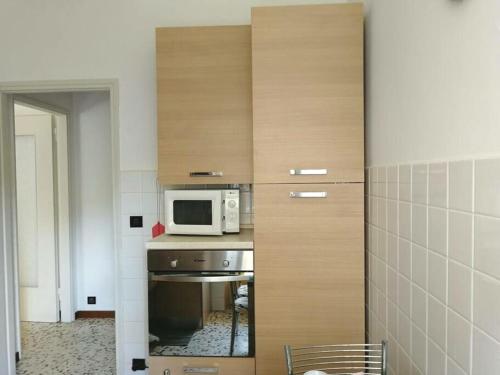 a small kitchen with a microwave and a table at Casa dolce casa, a 2 passi dal lago e vicina a Varenna in Lierna