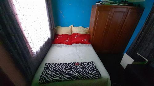a small bed in a room with a window at Edladleni inn in Phomolong