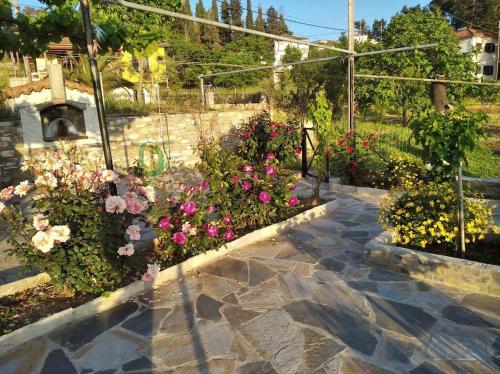 a garden with flowers and a stone walkway at Koeni House in Argalasti