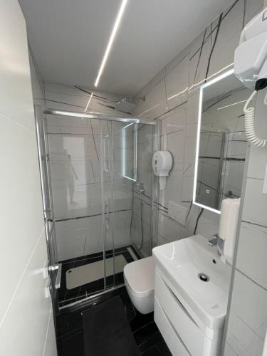 a white bathroom with a toilet and a sink at Villa San Sebastian-Baška in Baška