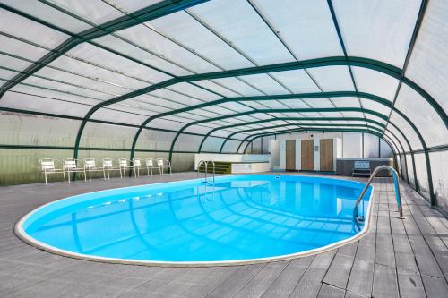a large swimming pool under a metal roof at Campsie Glen Holiday Park in Glasgow