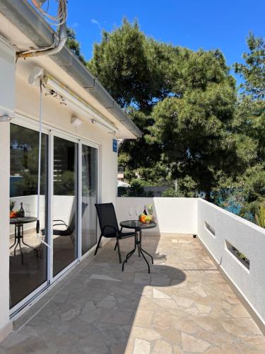 a patio with a table and chairs on it at Bronislovas holiday home in Rogoznica