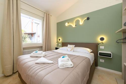 a bedroom with a large bed with towels on it at MGH Luxury - Villa Panorama in Bardolino