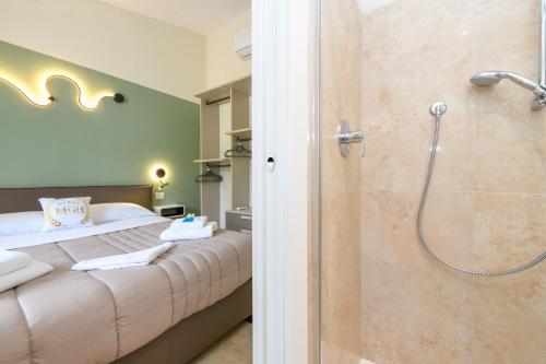 a bedroom with a king sized bed and a shower at MGH Luxury - Villa Panorama in Bardolino