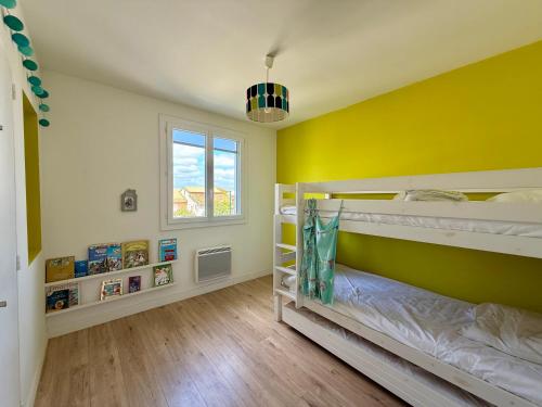 - une chambre avec 2 lits superposés et un mur jaune dans l'établissement Villa Salvador 4 Chambres Piscine, à Mauguio