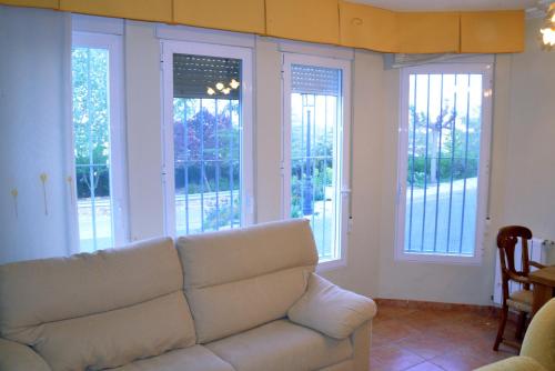 a living room with a white couch and windows at Casas Rurales el Jardín in Jorquera