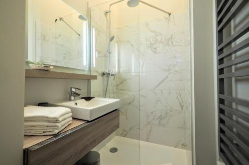 une salle de bain avec un lavabo et une douche en verre dans l'établissement Richelieu ChicSuites, à Paris