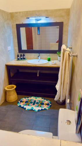 a bathroom with a sink and a mirror at Villa ArthurCC in Hikkaduwa