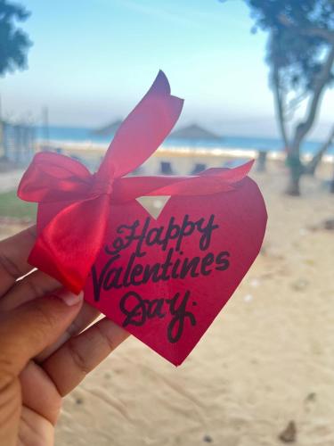 a person holding a heart with a red bow at Villa ArthurCC in Hikkaduwa