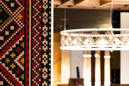 a chandelier and a rug on a wall at Mercure Szczyrk Resort in Szczyrk
