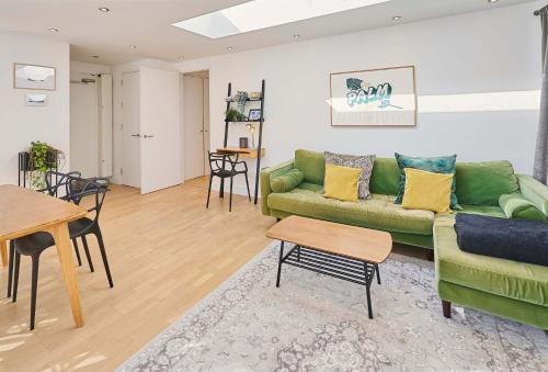a living room with a green couch and a table at Host & Stay - Palm Penthouse in Brighton & Hove