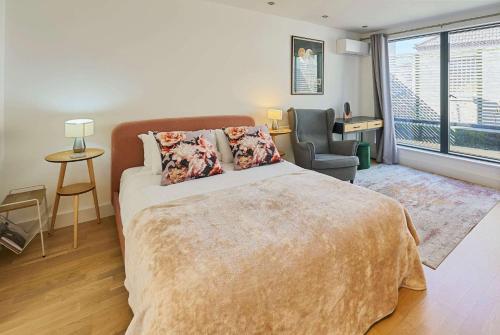 a bedroom with a bed and a chair and a window at Host & Stay - Palm Penthouse in Brighton & Hove