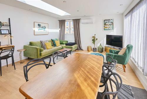 a living room with a table and chairs and a tv at Host & Stay - Palm Penthouse in Brighton & Hove
