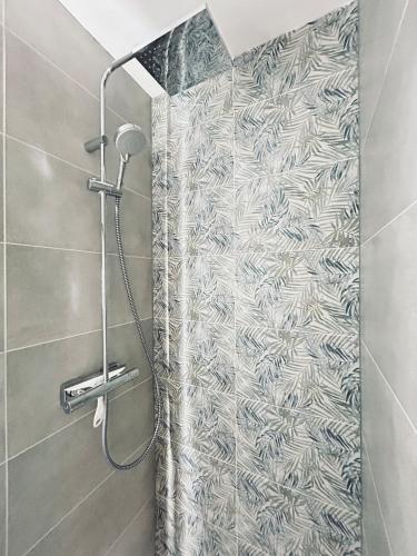 La salle de bains est pourvue d'une douche avec rideau de douche. dans l'établissement Chez Cath Studio neuf cosy proche centre-ville, à Reims